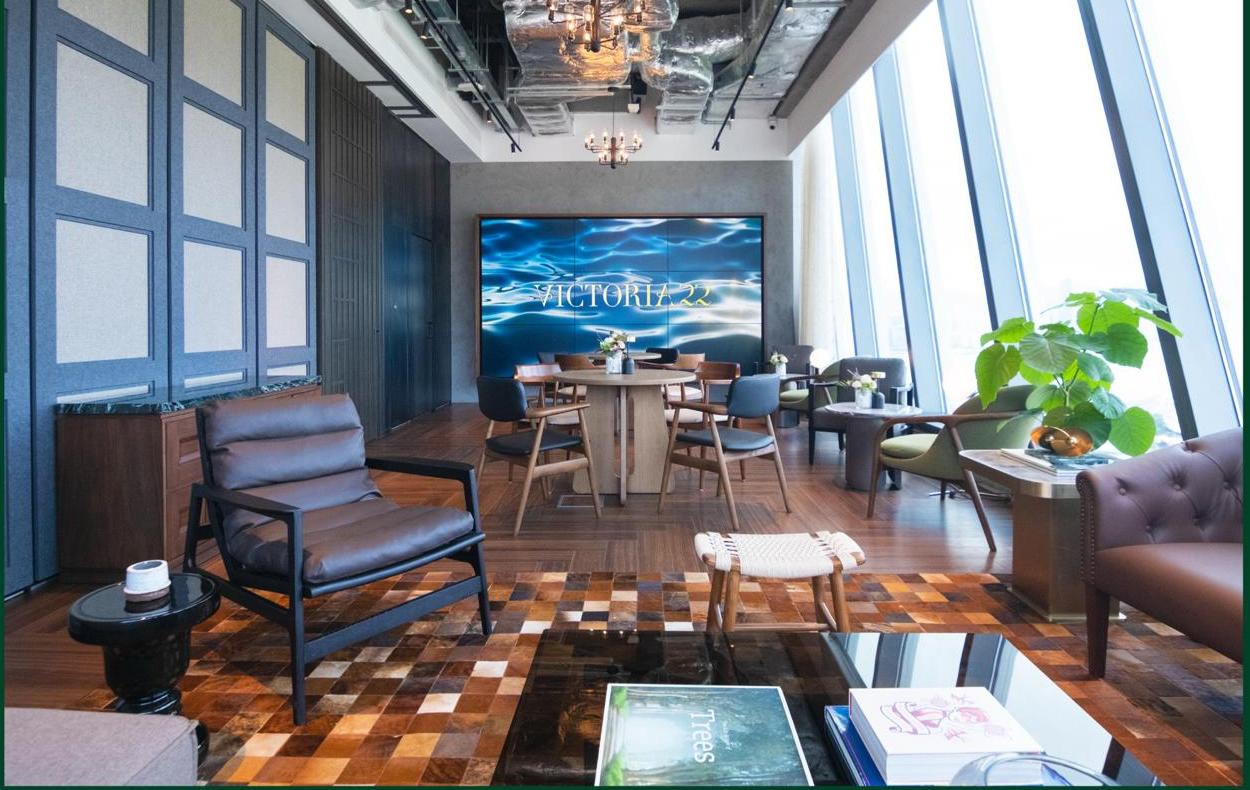 Victoria 22's lounge interior with warm wood furnishings and a branded video wall